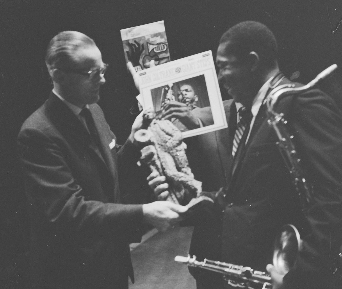John Coltrane ontvangt een Edison en houdt zijn saxofoon vast.