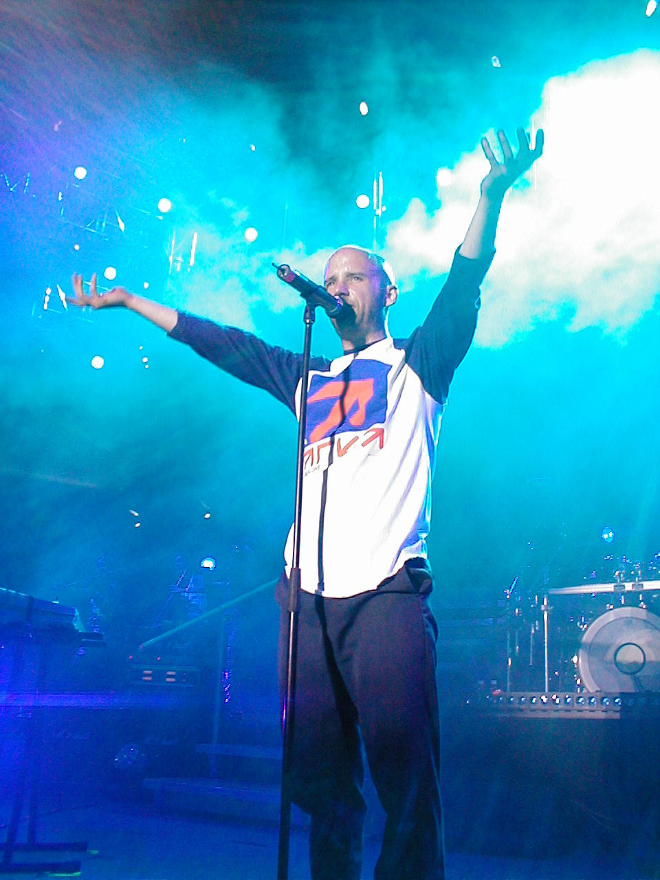 Moby zingt met beide armen omhoog tijdens Area One in 2001