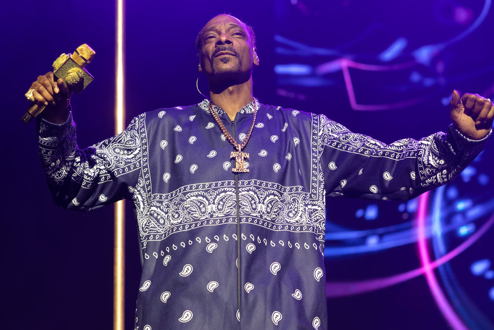 Snoop Dogg met gouden microfoon en gespreide armen tijdens zijn concert in Sydney op 1 maart 2023