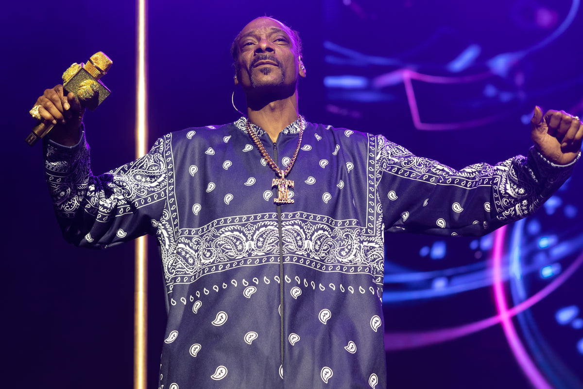 Snoop Dogg met gouden microfoon en gespreide armen tijdens zijn concert in Sydney op 1 maart 2023