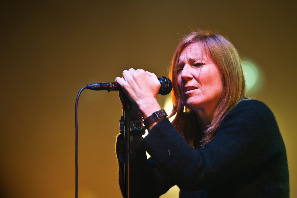 Beth Gibbons met gesloten ogen aan de microfoon tijdens een optreden van Portishead in Roskilde.