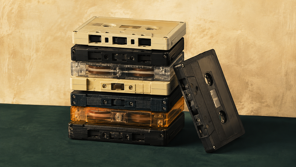 Stapel vintage cassettebandjes op een donkergroene ondergrond