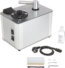 Zilveren platenspeler met reinigingsarm, schakelaars "MOTOR" en "VACUUM", reinigingsvloeistof, borstel en kabel.