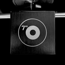 Zwarte houder met 7" symbool. Het symbool is een cirkel met een kleinere cirkel in het midden.