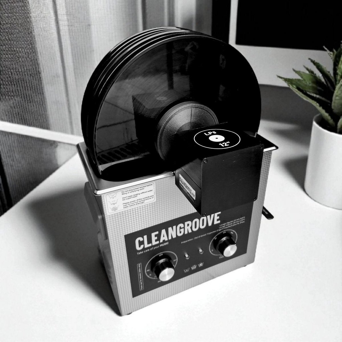 Vinyl reinigingsmachine met een stapel LP's die op de ultrasone reiniger zijn gemonteerd.