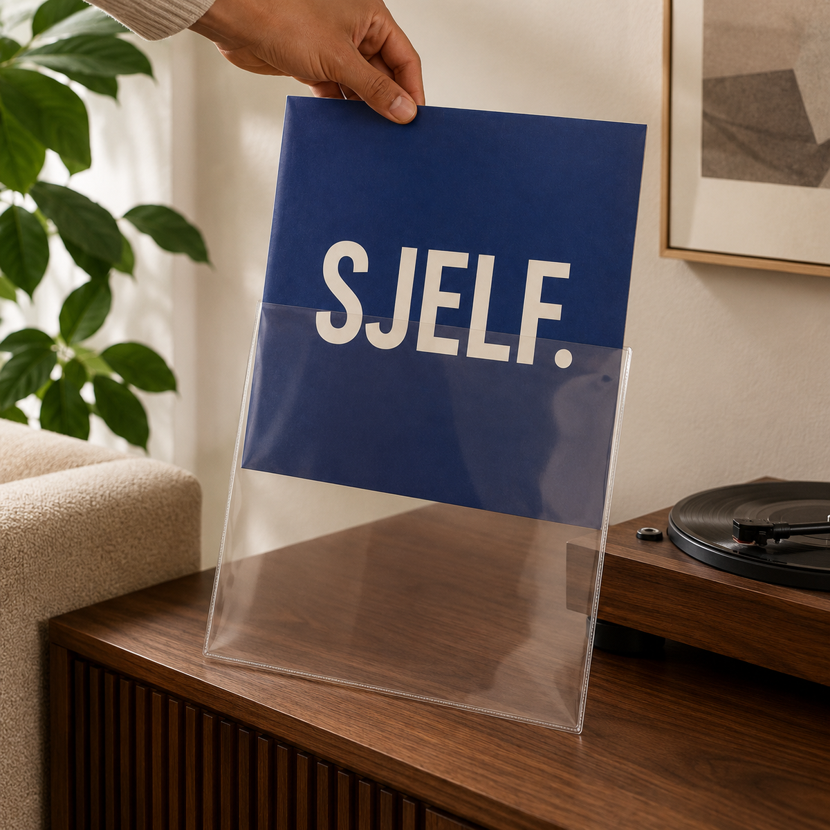 Blauwe vinyl albumhoes wordt in glasheldere beschermhoes geschoven