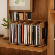 Walnootkleurige CD-houder met 4 vakken, gevuld met CD's.