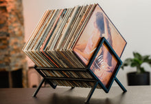 Zwart metalen platendrager met een stapel vinylplaten.